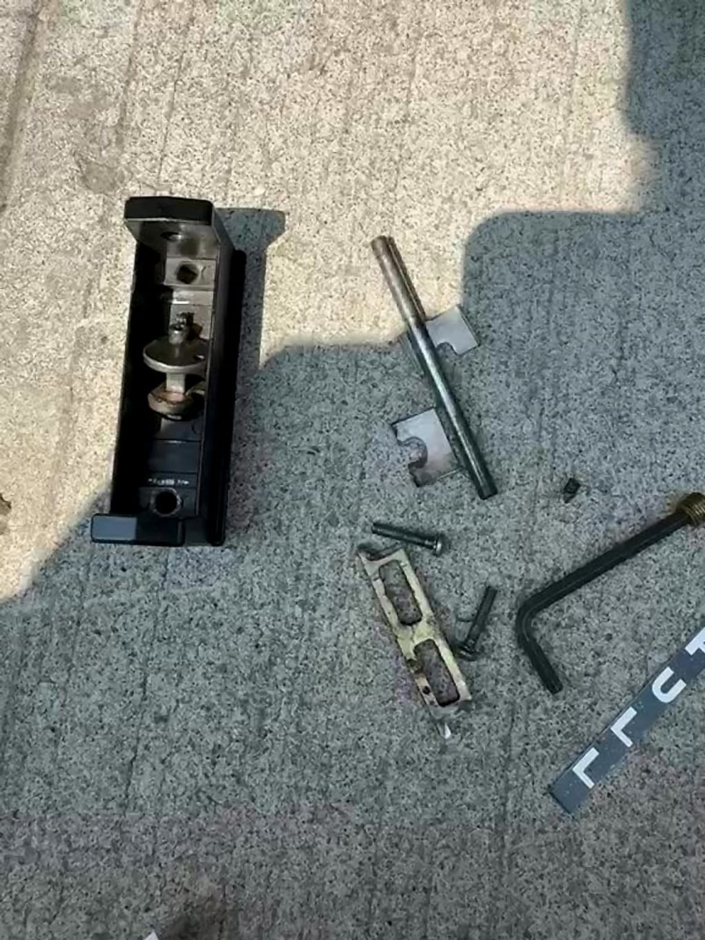 Old storefront door paddle housing and parts taken apart on the sidewalk