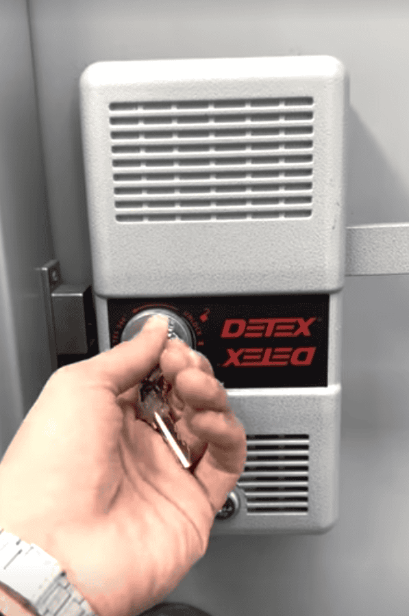 Key in the key switch of a Detex exit control lock mounted on a metal door